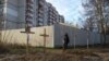 A man stands next to graves with bodies of civilians, who according to local residents were killed by Russian soldiers, in Bucha, outside Kyiv, in April 2022.