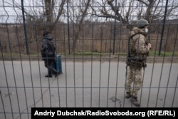 Жінка з валізою рухається в бік підконтрольної Україні території на КПВВ «Станиця Луганська», 26 листопада 2021 року