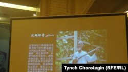 Бээжин шаарында 2015-жылдын тогуздун айынын 19-20унда өткөрүлгөн “Жуңгодогу уйгур дастандары боюнча эл аралык туңгуч илимий жыйындын” маалындагы баяндамадагы дастанчы Курбаннияз Курбандын сүрөтү.