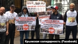 Rusiye Yuqarı mahkemesi ögünde Bağçasaraydaki birinci «Hizb ut-Tahrir davası» boyunca mahküm etilgen qırımtatarlarğa qoltutuv aktsiyası. Moskva, 2019 senesi iyülniñ 11-i