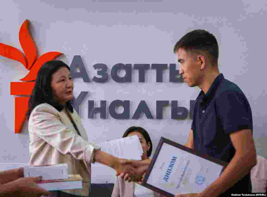 &quot;Эркин Европа/Азаттык&quot; радиосунун кыргыз кызматынын директору Венера Жуматаева сынактын жеңүүчүлөрүнө сыйлык тапшырууда.&nbsp;