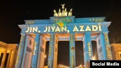 نورپردازی شعار «زن زندگی آزادی» بر دروازۀ براندنبورگ در برلین، آذر ۱۴۰۱