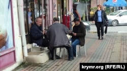 Мужчины играют в карты у магазина на улице Пушкина