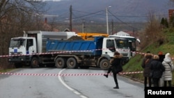 Local Serbs walk near a roadblock in Rudare, near the northern part of the ethnically divided town of Mitrovica, Kosovo, on December 13.