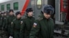 Russian conscripts called up for military service walk along a platform before boarding a train as they depart for garrisons at a railway station in Omsk. (file photo) 