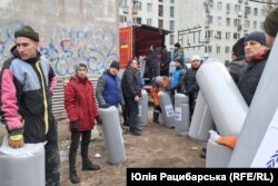 Добровольці розвантажують матраци для постраждалих