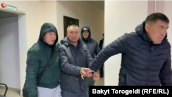 Таалайбек Мадаминов (ортодо кишен салынган адам).