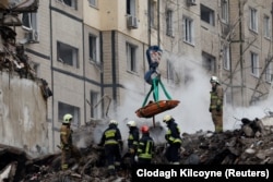 Співробітники екстреної допомоги дістають тіло мертвого в Дніпрі, після ракетного удару РФ по багатоквартирному будинку, 15 січня 2023 року