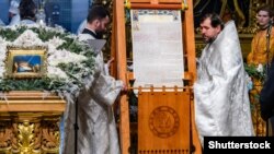 Священики ПЦУ представляють томос про автокефалію для Православної церкви України після Різдв’яної Літургії в Софійському соборі в Києві, 7 січня 2019 року