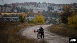 Ілюстраційне фото. Жінка на велосипеді залишає місто Бахмут, жовтень 2022 року
