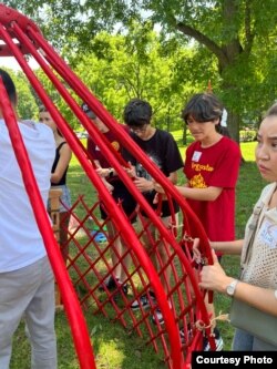 Айдан-Азамат помогает в установке юрты.