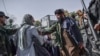 A Taliban militant tries to stop a woman from protesting at a march in Kabul on October 21.