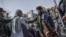 A Taliban militant tries to stop a woman from protesting at a march in Kabul on October 21.