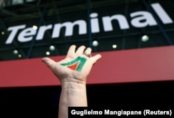 یکی از معترضان به انحلال آلیتالیا، نشان این شرکت را در فرودگاه فیومیچینو بر کف دست خود نقاشی کرده است/ ۲۱ مهر ۱۴۰۰