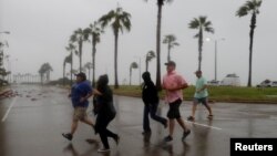 Група жителів міста Корпус-Крісті перебігає дорогу під поривами вітру від урагану «Гарві», штат Техас, 25 серпня 2017 року