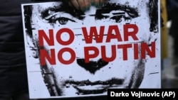 A protester holds a banner depicting Russian President Vladimir Putin during a protest organized by the Russian Democratic Society in Belgrade in December 2022.