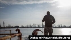 Богослужіння, пірнання в ополонку, благословення коней, запливи: традиції Водохреща (фотогалерея)