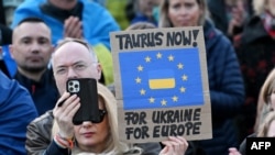 Учасник демонстрації біля Бранденбурзьких воріт на підтримку України тримає плакат із написом «Taurus now – for Ukraine, for Europe», 9 березня 2025 року, Берлін