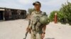 A Kyrgyz soldier stands guard near a burned border post in the village of Maksat in Batken Province on May 4.
