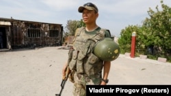 A Kyrgyz soldier stands guard near a burned border post in the village of Maksat in Batken Province on May 4.