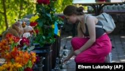 Կրեմենչուգի հրթիռակոծությունից հետո կինը մոմ է վառում առևտրի կենտրունում