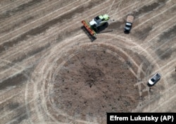 Воронка від влучення російської ракети на українському полі за десяток кілометрів від лінії фронту, де точаться запеклі бої. Україна, 4 липня 2022 року