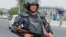 An Uzbek law enforcement officer guards on a street in Nukus on July 3. 