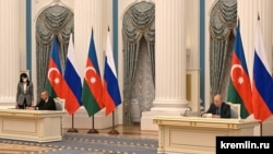Президенты России и Азербайджана - Владимир Путин (справа) и Ильхам Алиев - подписывают декларацию о российско-азербайджанском союзническом взаимодействии, Москва, 22 февраля 2022 г.