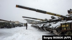 Військовослужбовець ЗСУ стоїть перед танками 92-ї окремої механізованої бригади, Харківська область, 31 січня 2022 року