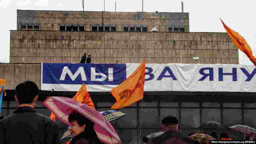 Akimiyet namzetiniñ tarafdarları, Ukrain muzıkalı teatrniñ binasına &quot;Mı za Yanukoviça&quot; (&quot;Biz Yanukoviç içün&quot;) yazısını asmağa tırışa, amma şiddetli yel olarğa keder etti.