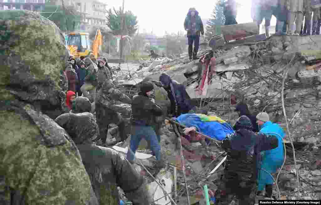Российские военные и сирийские мирные жители во время поисково-спасательных работ в сирийском регионе Латакия. Фото впервые опубликовано 7 февраля. Сирия вовлечена в десятилетнюю гражданскую войну. От землетрясения пострадали как контролируемые правительством районы, так и удерживаемые повстанцами населённые пункты
