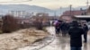 People stand by the river in Novi Pazar, Serbia, on January 19.
