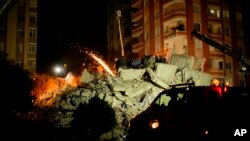 Спасатели разбирают руины разрушенного землетрясением здания. Адана, Турция, 7 февраля 2023 года