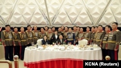 Ким Чен Ын, его жена Ли Соль Чжу (слева) и их дочь Ким Чжу Э (стоит возле отца в центре) за столом в окружении военачальников на банкете в честь 75-летия Корейской народной армии. Пхеньян, 7 февраля 2023 года