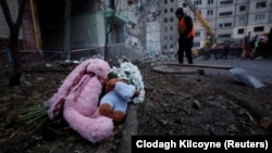 Днепрге урулган соккуда курман болгондордун эскергендер калтырып кеткен гүл жана оюнчуктар. 