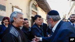 حاخام یوسف حمرا (راست) در حال خوش‌وبش با همسایه‌ها در بافت قدیمی شهر دمشق