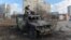 A soldier examines a destroyed Russian infantry mobility vehicle after a fight in Kharkiv on February 27.