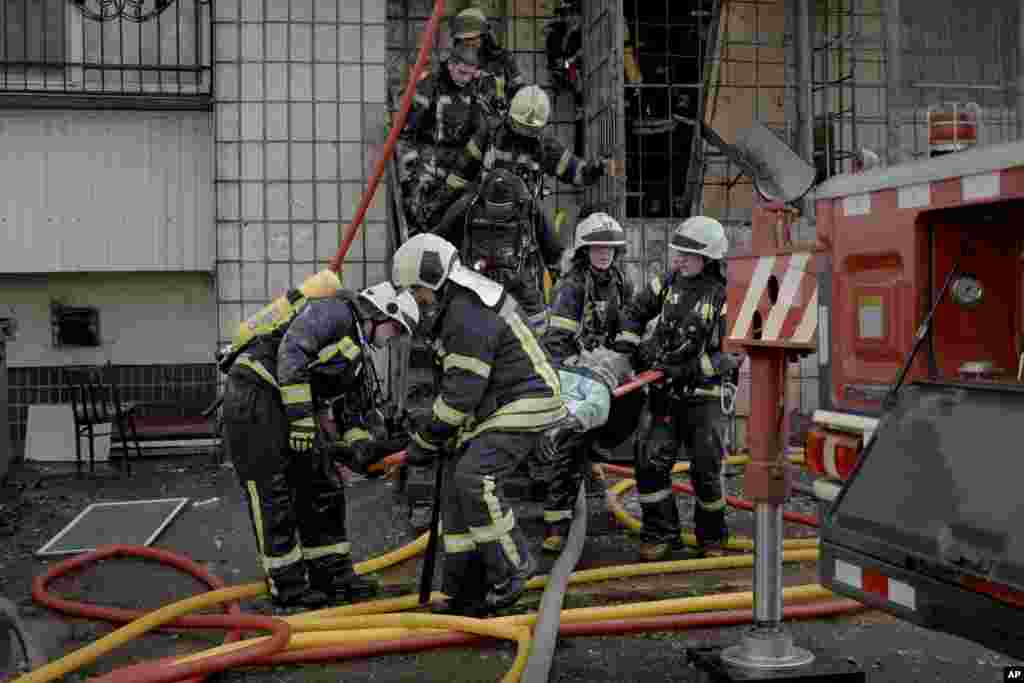 Киев. Орусиялык күчтөрдүн аткылоосунан кийин курман болгон аялдын сөөгүн чыгарып жаткандар. 15-март, 2022-жыл.&nbsp;