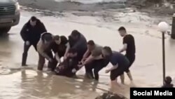 Жители города Актобе вытаскивают из талой воды упавшую девочку. Скриншот с видео