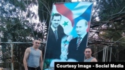 Орусиялык жоокерлер Путин менен Башар Асаддны сүрөтүнүн жанында турат