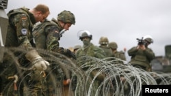 Kosovo -- German KFOR soldiers emove barbed wire from the road in the village of Jagnjenica, 05Dec2011