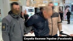 За даними СБУ, затриманий «обіцяв одній із комерційних структур «уникнення» економічних санкцій РНБО за хабар у 500 тис. доларів США»