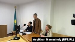 Подсудимый по делу о гибели пастуха во время Январских событий в Талдыкоргане Марк Злуняев. Слева от него его мать Татьяна Злуняева, справа — адвокат Гульнара Валимова. 20 октября 2022 года