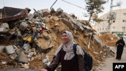 زنی فلسطینی در حال عبور از کنار آثار حملات اسرائیل به رفح