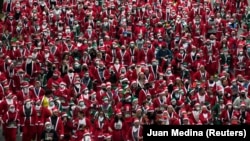 Люди в костюмах Санта-Клауса беруть участь у благодійному забігу зі збору коштів на допомогу постраждалим від виверження вулкану Кумбре-В’єха в Мадриді, Іспанія, 19 грудня 2021 року.