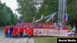 Фота ўдзельнікаў велапрабегу каля ўязнога знаку ў Магілёў