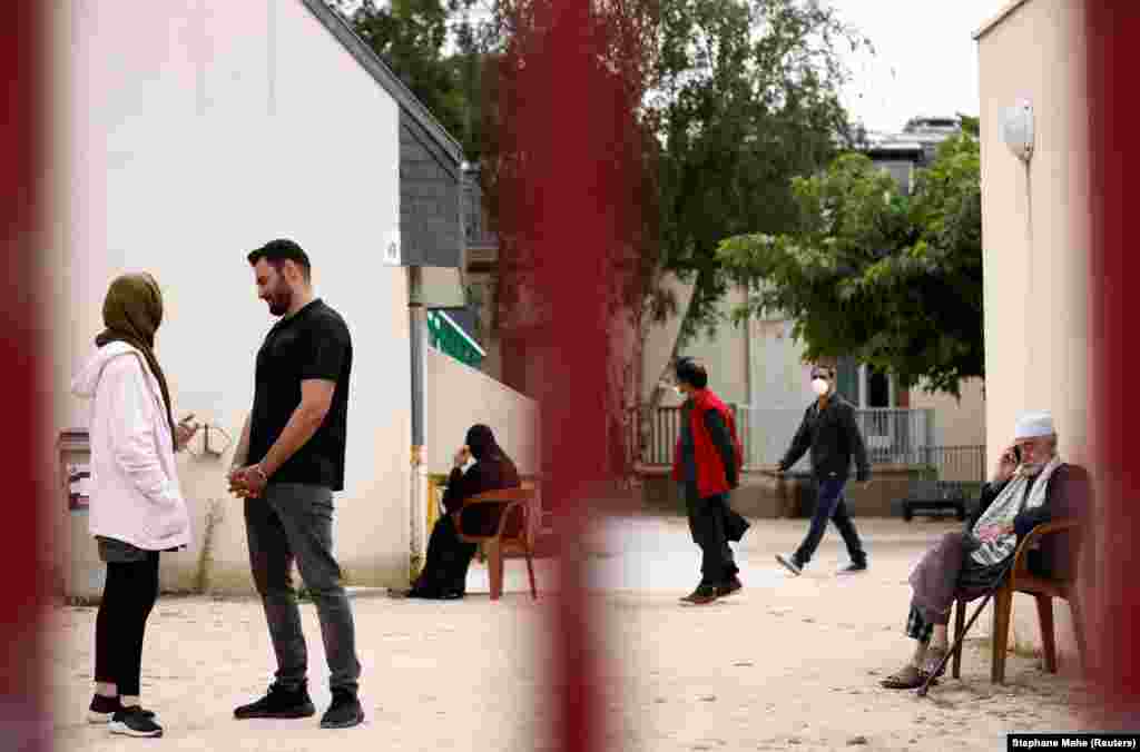 Афганські біженці Асма Халімі, 25 років і Мохаммад Омер Айуб, 29 років, розмовляють у дворі центру прийому Разай в Піріак-сюр-Мер, Франція, після їхньої евакуації з Афганістану минулого тижня