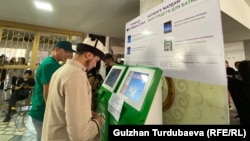 Баткенге жардам үчүн ачылган атайын эсепке акча которуп жаткан жарандар. Спорт сарайы, Бишкек. 18-сентябрь, 2022-жыл.