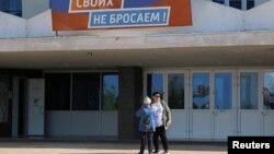 Women stand outside a polling station during the first day of a referendum on joining Russian-controlled regions of Ukraine to Russia in Sevastopol, Crimea, on September 23.