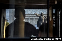 Протестувальник дивиться на статую Леніна в Бішкеку, 2021 рік